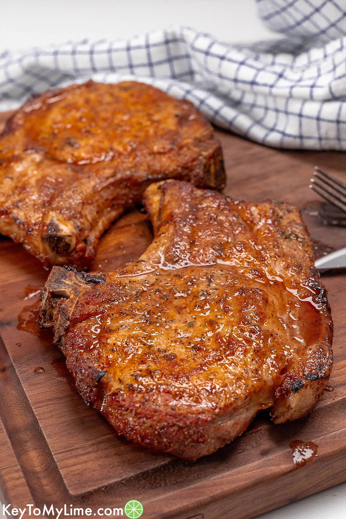 A side image of pork chops on a cutting board showing the crispy edges.