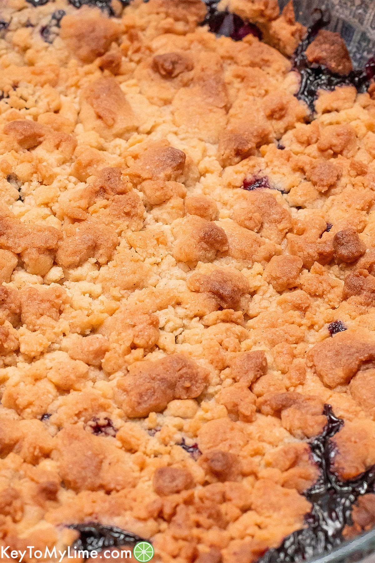 An overhead image of a freshly baked cobbler with pie filling bubbling out.