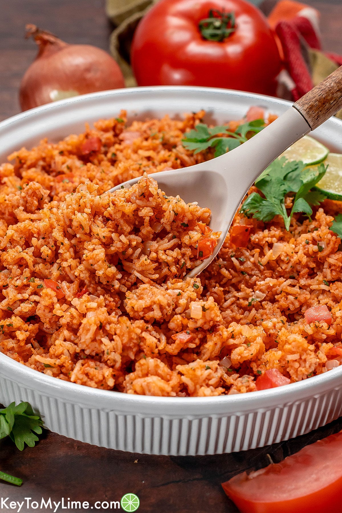 Close up image of Mexican rice being lifted up on a serving spoon.