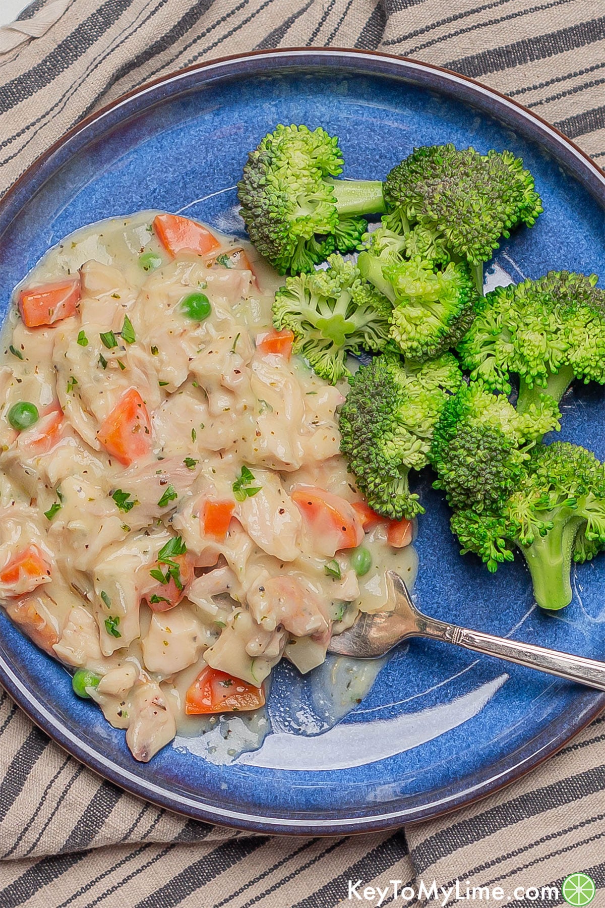 A serving of crustless chicken pot pie with broccoli on a plate.