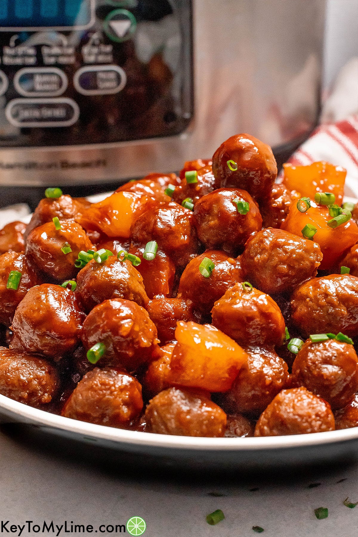 A side image of meatballs on a plate with pineapple chunks throughout.