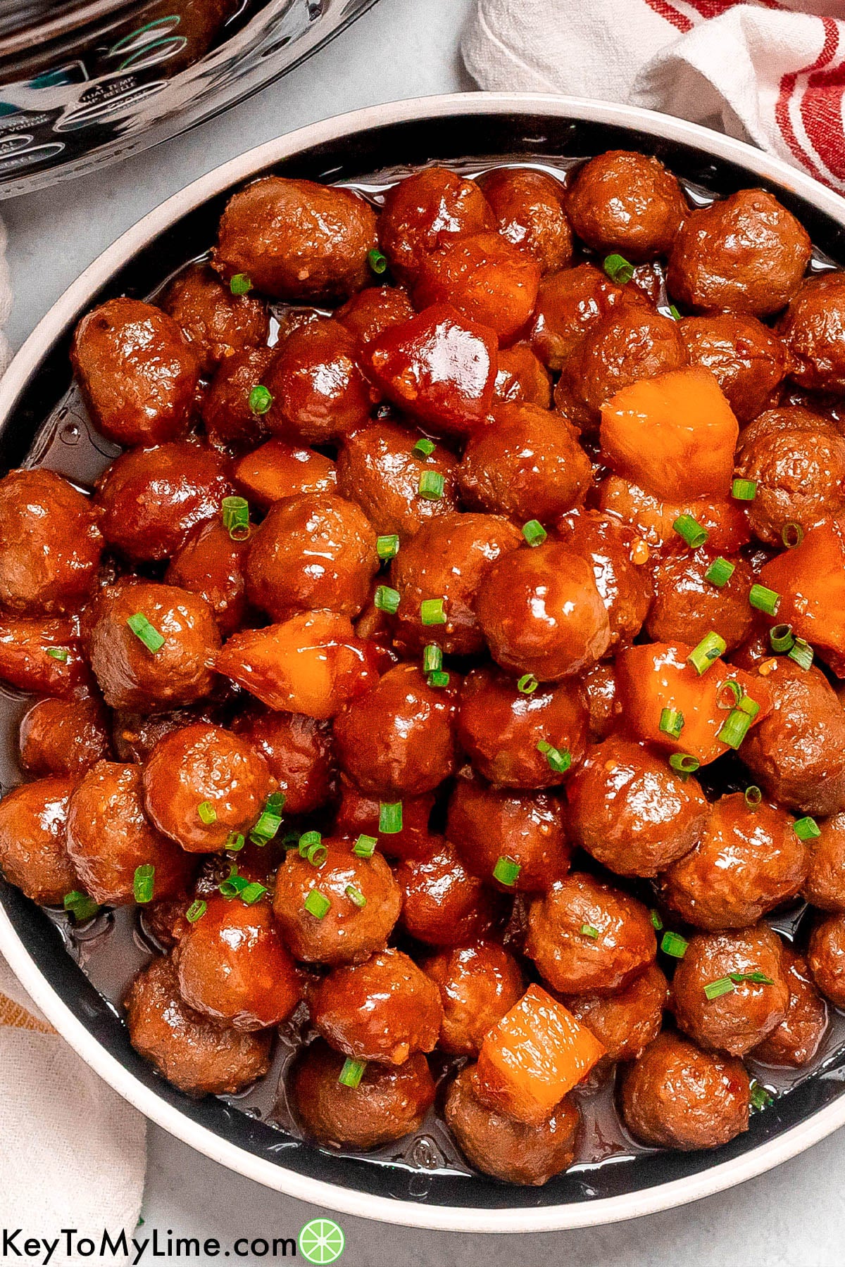 An overhead image of crockpot meatballs stacked on a serving dish.