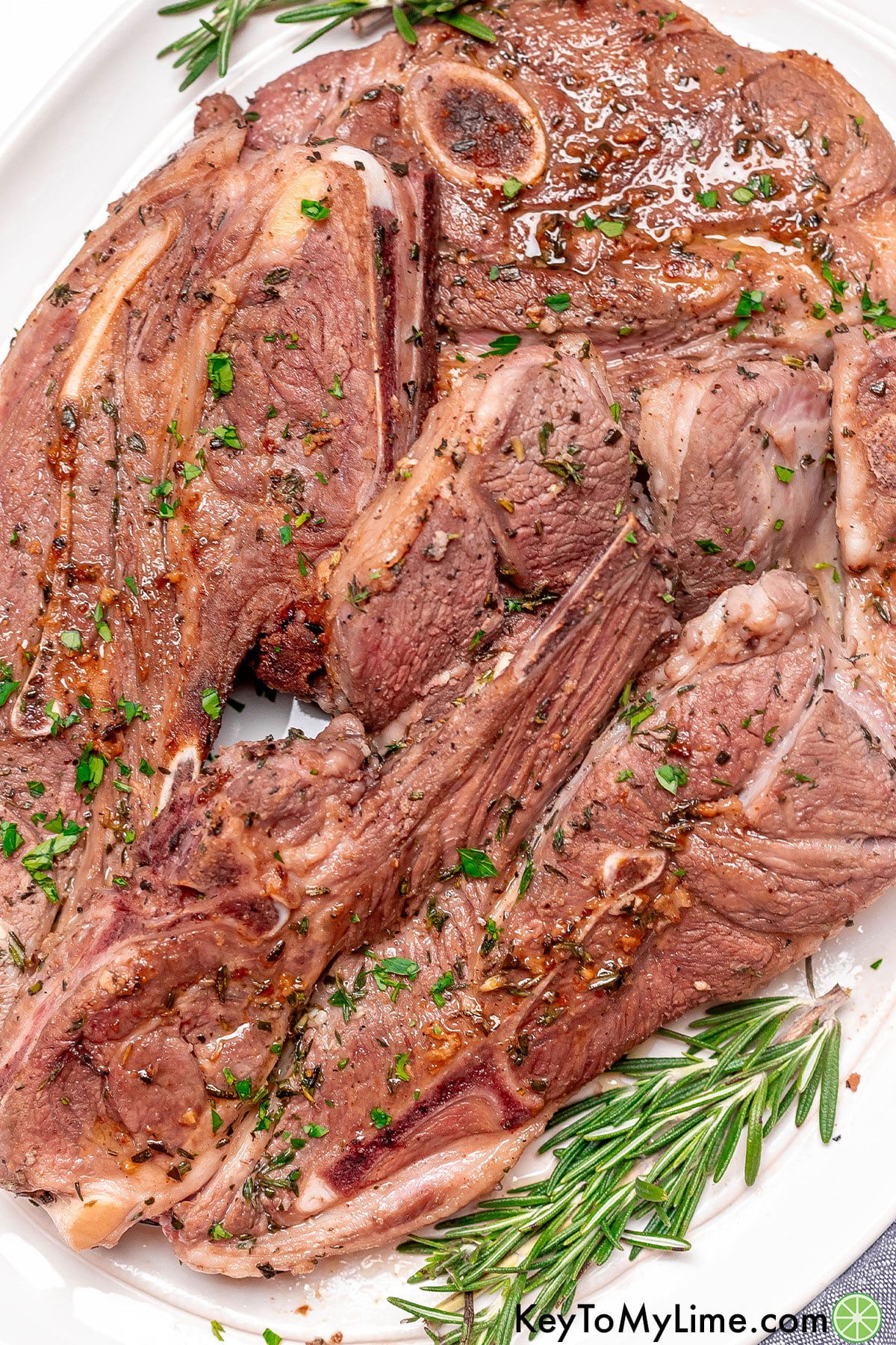 A few chops resting on a large platter with garnish to the side.