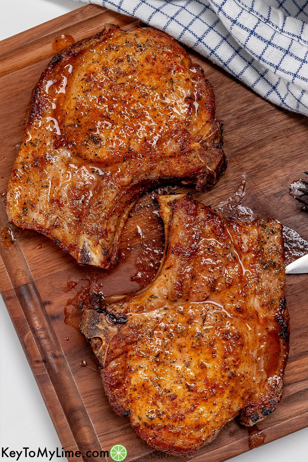 An overhead image of bone in pork chops resting on a cutting board.
