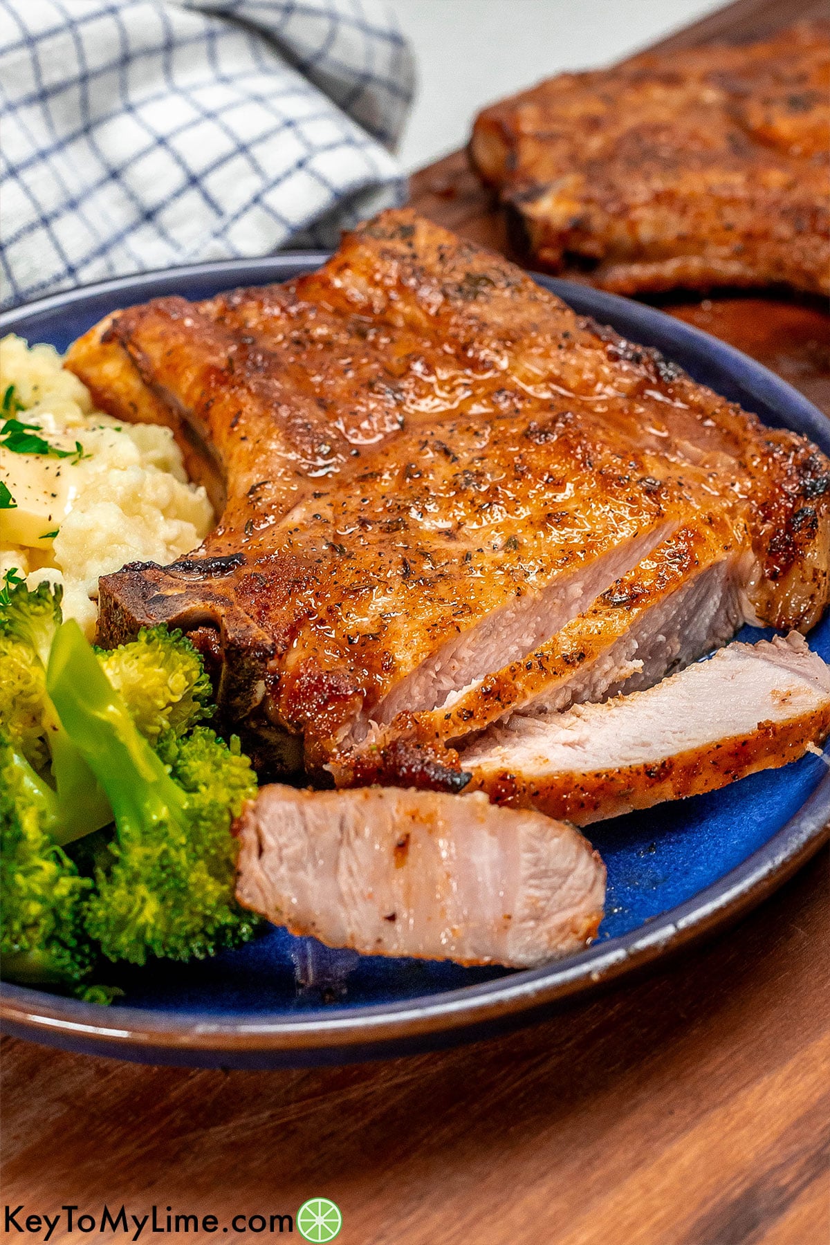 Seasoned pork chops plated next to creamy mashed potatoes.