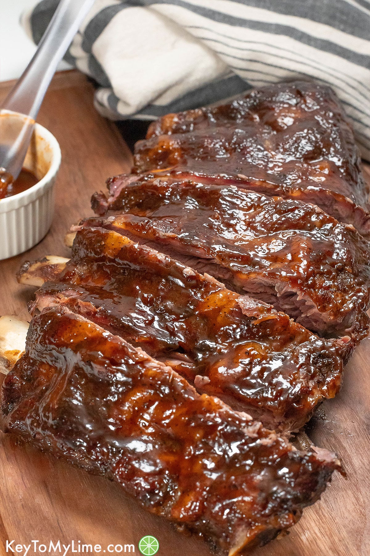 A rack of beef ribs sliced with fresh BBQ sauce brushed on top.