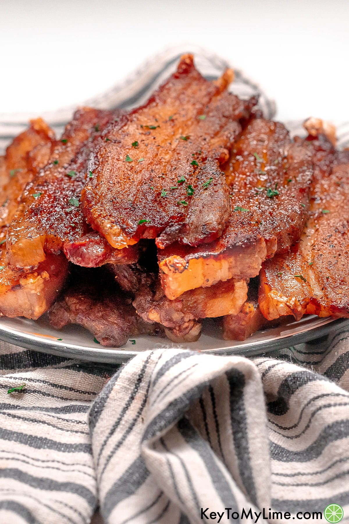 A side image of crispy pork belly strips resting on a plate.
