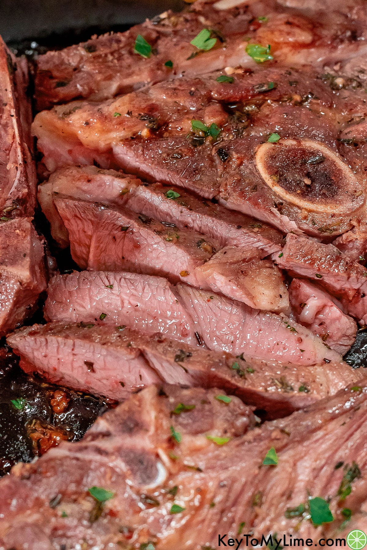 Freshly sliced lamb shoulder chops with seasonings throughout.