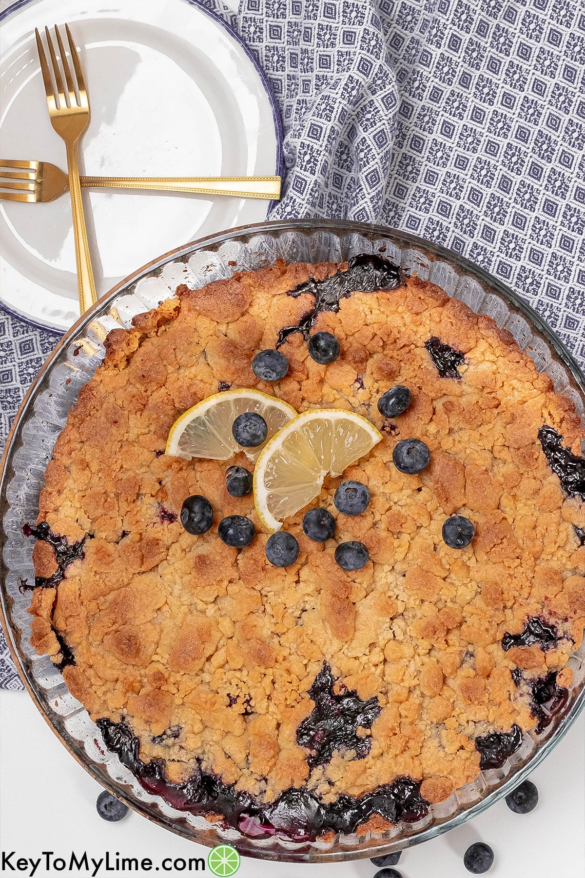 A whole cobbler in a baking dish with fresh blueberries on top.